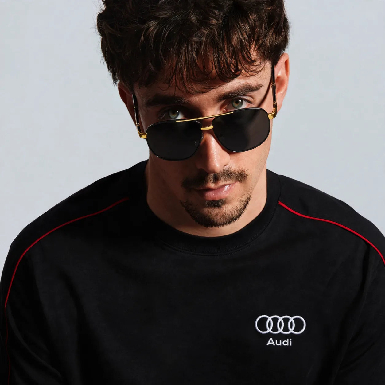 Illustrative styling montage: Q5 black and gold sunglasses with Audi shirt